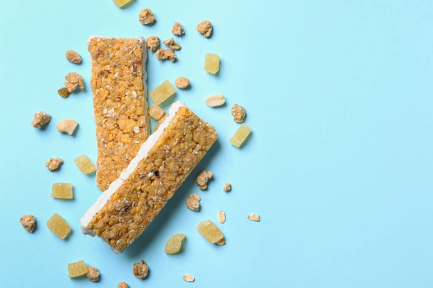Healthy granola bars on blue background, flat lay. Space for text - Fotó, kép