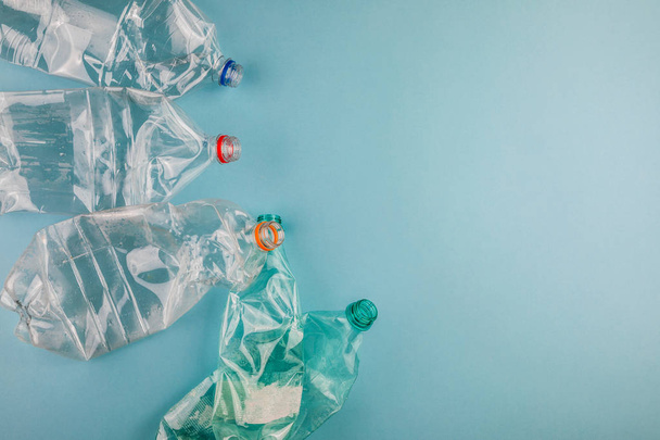 Crumpled plastic bottles on a blue background. Plastic trash. - Zdjęcie, obraz