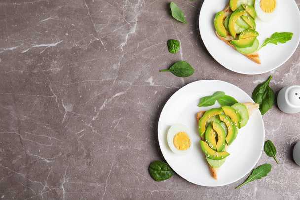 Flat lay composition with avocado toasts on marble table, space for text - Photo, Image