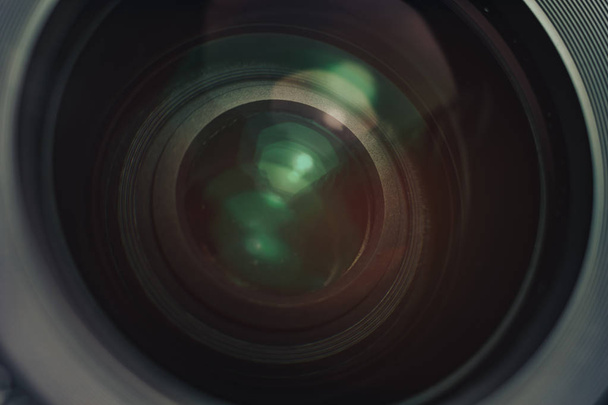 Mooie camera lens met geel en roze licht van glas op een zwarte achtergrond. - Foto, afbeelding