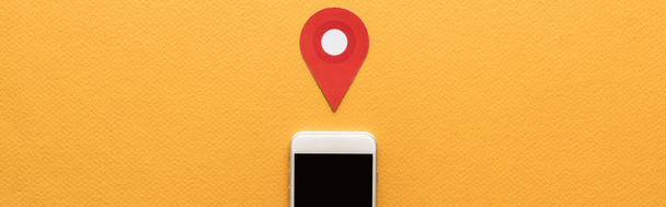 πάνω όψη του χάρτου κοπεί το σήμα θέση κοντά smartphone με λευκή οθόνη σε πορτοκαλί φόντο, πανοραμική λήψη - Φωτογραφία, εικόνα