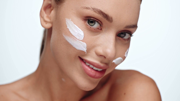 woman applying cosmetic cream and smiling isolated on white - Footage, Video