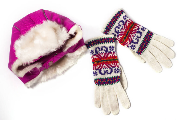 Winterflach, warmrosa Mütze mit Ohrenklappen und gestrickte Wollhandschuhe auf weißem Hintergrund. Draufsicht, Attrappe. - Foto, Bild
