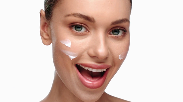 žena s úsměvem a použití kosmetické krém izolované na bílém - Záběry, video