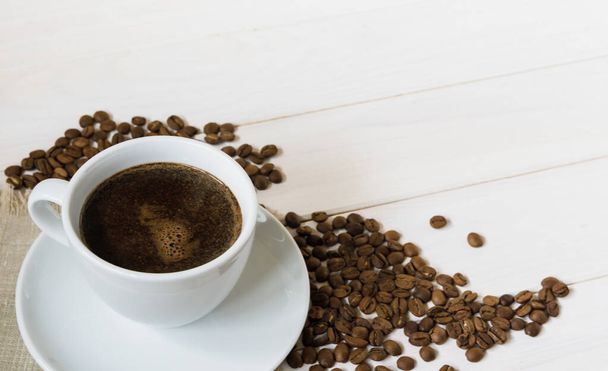 xícara de café e grãos de café na mesa de madeira - Foto, Imagem