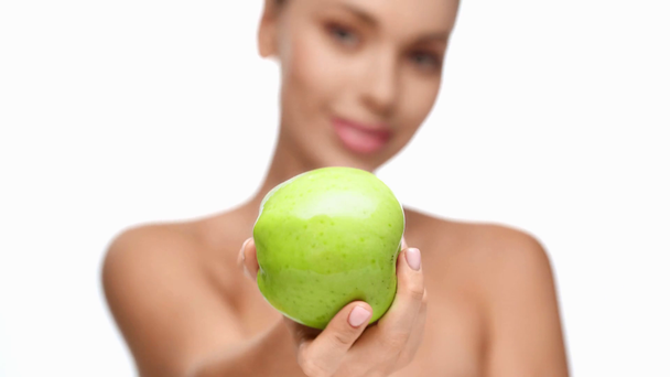 mujer sonriendo y mostrando manzana a cámara aislada en blanco
 - Metraje, vídeo