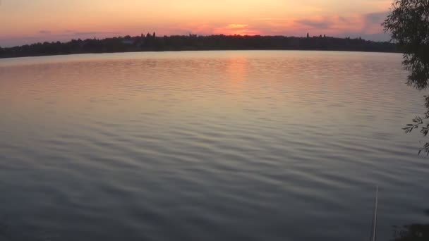 Nyári naplemente a nyugodt folyó hátterében - Felvétel, videó