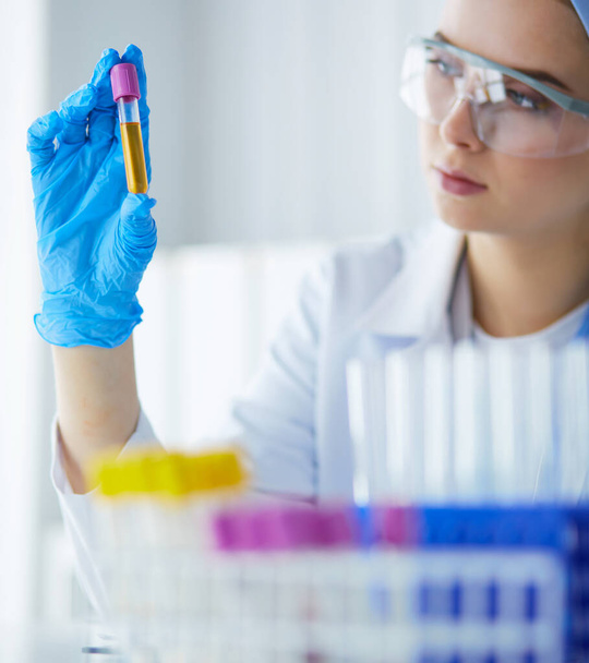 Laboratory assistant woman analyzing a blood sample - Photo, Image