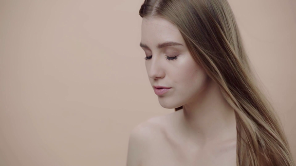 slow-motion van meisje aanraken haar geïsoleerd op beige  - Video