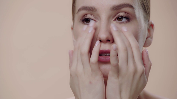 close up de mulher fazendo massagem facial isolada no bege
  - Filmagem, Vídeo