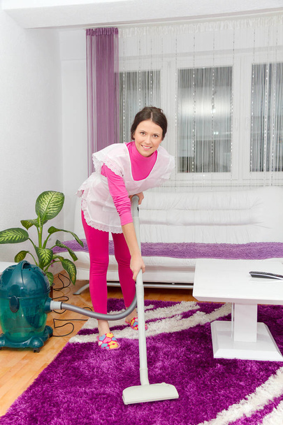 Красивая молодая женщина чинит пылесос дома
 - Фото, изображение
