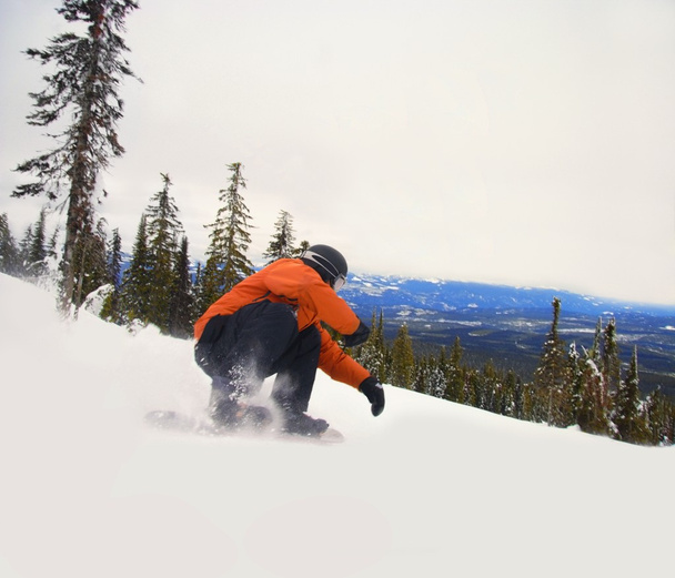 Snowboarder Crouching Down Low As He Descends Snow Hill - Fotoğraf, Görsel