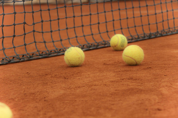 Kırmızı sahada gri ağlı tenis topları - Fotoğraf, Görsel