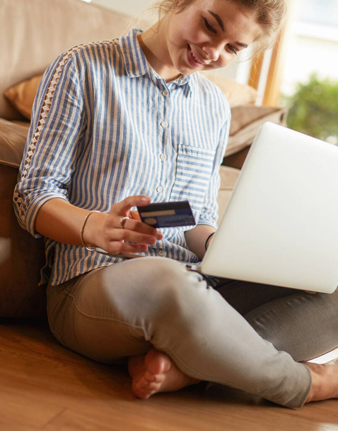 Beautiful young woman using credit card and laptop for online shopping - Foto, imagen