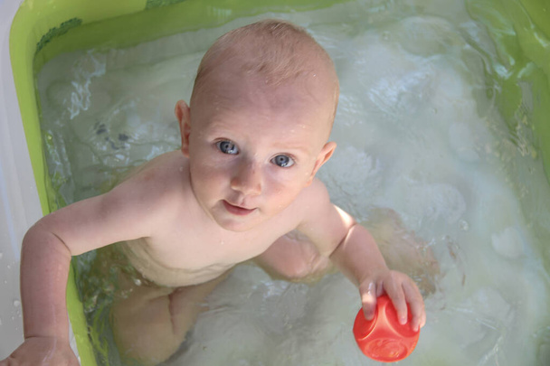 Mooi een jaar baby jongen spelen in het zwembad - Foto, afbeelding