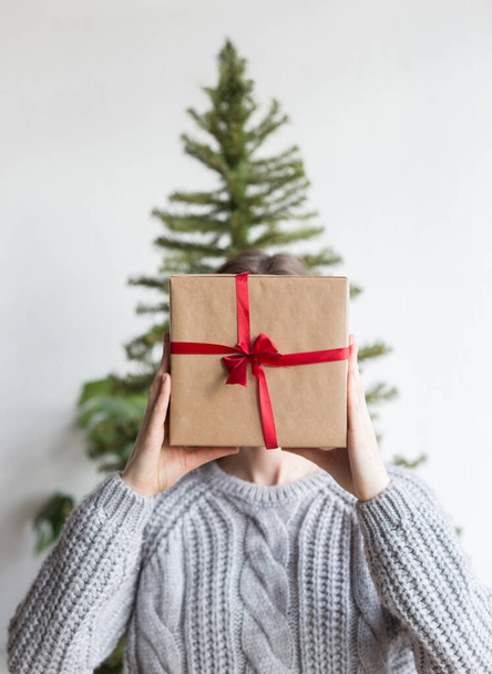 Woman hold a wrapped gift box with christmas tree - Фото, изображение