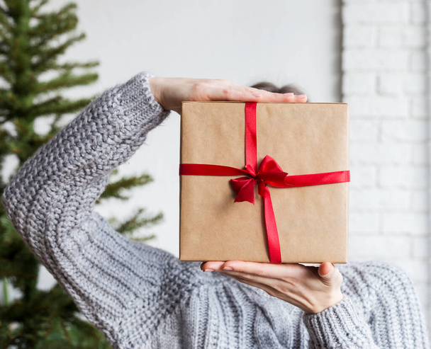 Craft paper wrapped box in hand with christmas tree - Zdjęcie, obraz