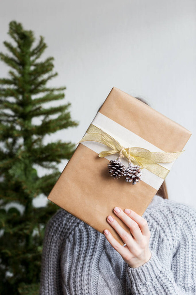 Woman hold a present box with christmas tree - Foto, afbeelding