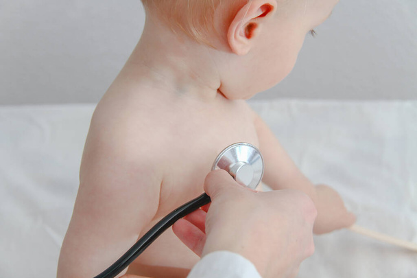 One year old sick baby boy at the young female doctor - Foto, imagen