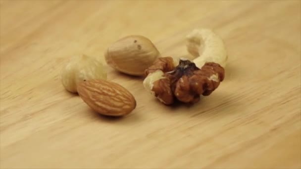 different nuts rotate 360 degrees on a wooden platform - 映像、動画