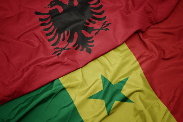 ondeando colorida bandera de senegal y bandera nacional de albania
. - Foto, imagen