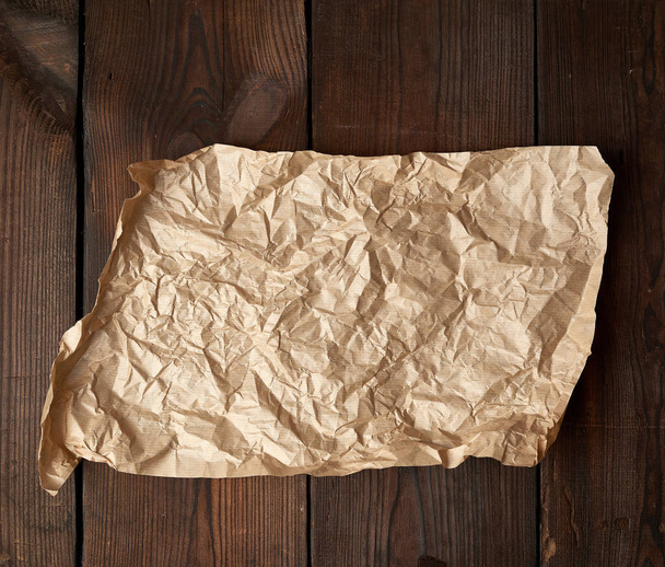 pedazo roto vacío de papel de hornear arrugado marrón en una mesa de bo
 - Foto, imagen
