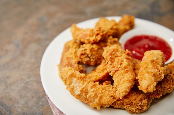close up view of delicious chicken nuggets with ketchup on stone surface - Valokuva, kuva