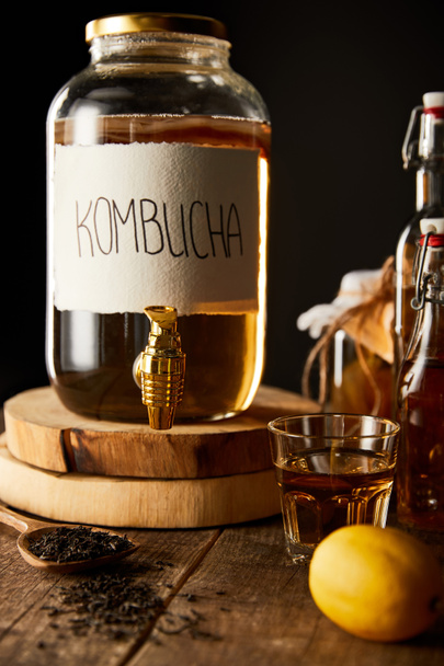 glass jar with kombucha on wooden table isolated on black - Photo, Image