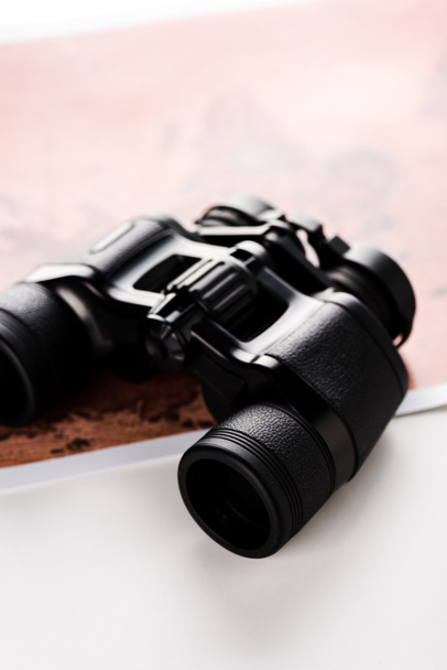selective focus of binoculars near map on white  - Photo, Image