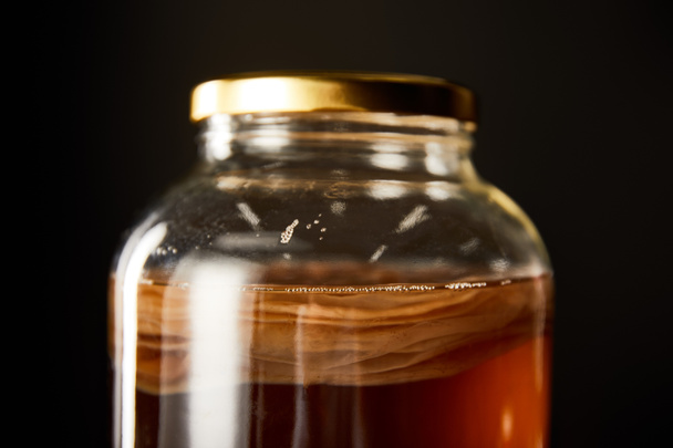 close up view of glass jar with kombucha isolated on black - Photo, Image