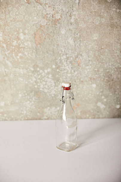 botella de vidrio vacío cerca de la pared gris piedra
 - Foto, Imagen