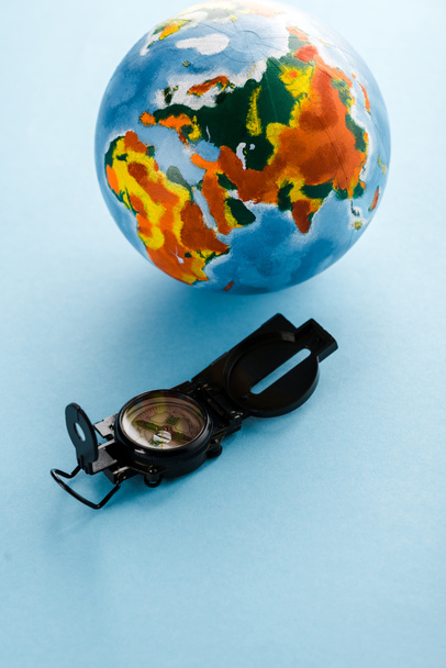 retro compass near colorful globe on blue  - Photo, Image