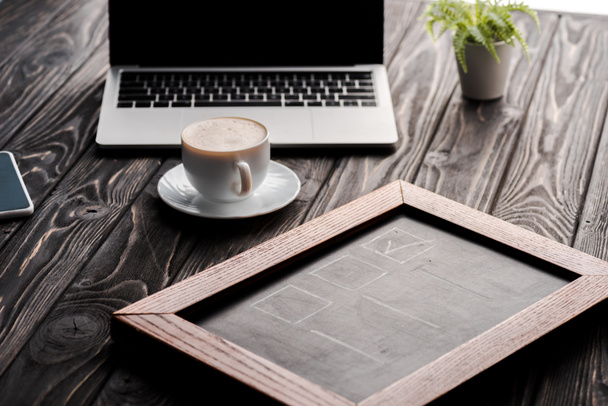selektywne skupienie tablicy kredy w pobliżu filiżanki kawy i laptopa na stole, koncepcja e-commerce - Zdjęcie, obraz