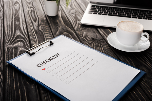 selective focus of clipboard with checklist near laptop and cup of coffee on table, e-commerce concept - Fotografie, Obrázek