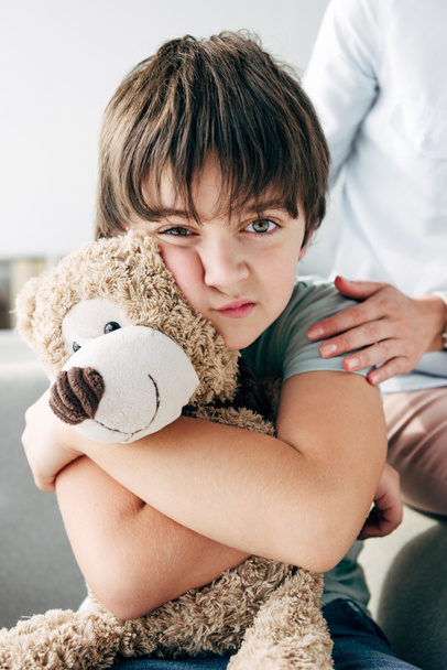 niño con dislexia sosteniendo oso de peluche y psicólogo infantil abrazándolo
  - Foto, Imagen