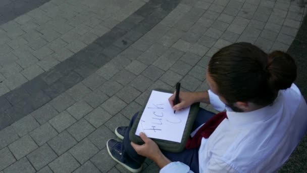 Κουρασμένος άνθρωπος γράφει σκατά off πινακίδες σε εξωτερικούς χώρους. - Πλάνα, βίντεο