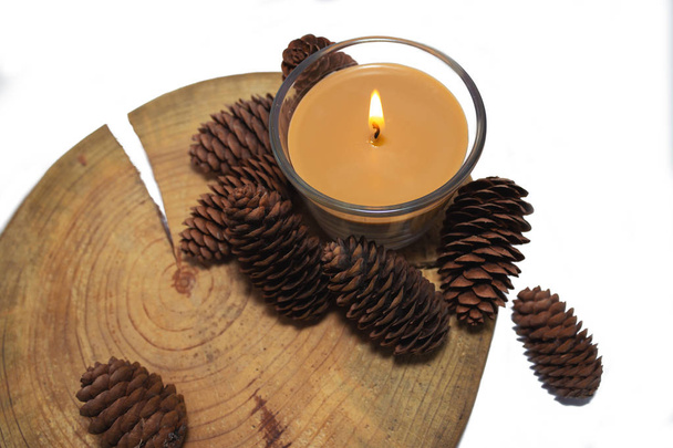 Fondo de Navidad y Año Nuevo con velas y conos sobre una vieja mesa de madera de estilo rústico, sobre fondo blanco
 - Foto, Imagen