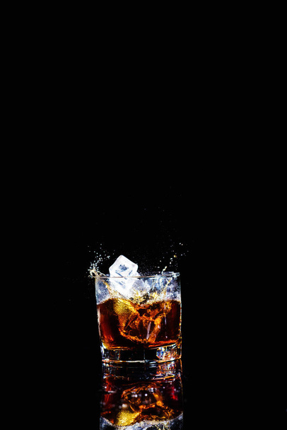 Isolated shot of whiskey with splash on black background - Zdjęcie, obraz