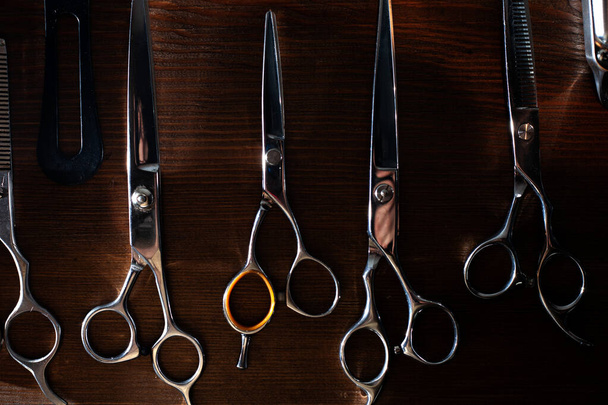 tijeras, navaja de afeitar, trimmer y boquillas se encuentran en una mesa de madera, un conjunto de equipos de peluquería, herramientas de peluquería
 - Foto, imagen