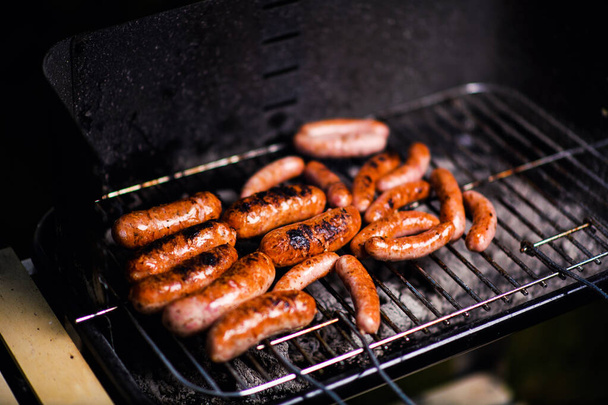 Grilled sausage on the flaming grill - Foto, afbeelding