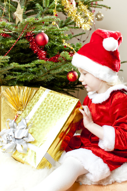 Маленькая девочка, как Санта Клаус с рождественскими подарками
 - Фото, изображение