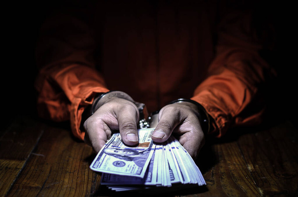 Close-up Of male  Hands  In handcuffs  with dollars  - Fotó, kép