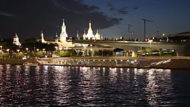 MOSCOW, RUSSIA - AUGUST  11, 2019: Floating bridge of Zaryadye park on Moskvoretskaya Embankment of Moskva River (and tourist pleasure boat) at Night. Moscow, Russia.  - Video