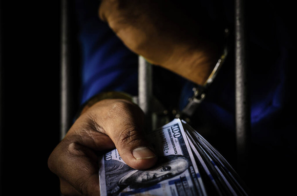 Close-up Of male  Hands  In handcuffs with dollars  - Photo, image