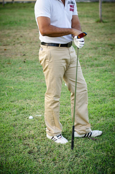 Golfer man staande en het houden van een golfclub voor het spelen van golf - Foto, afbeelding