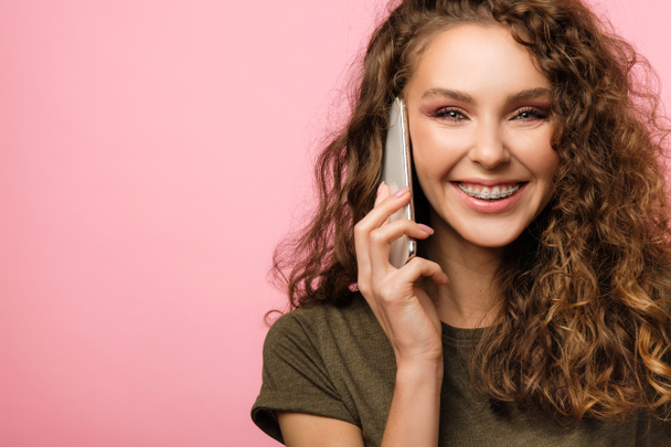 Pretty girl with cellphone on pink background - Foto, immagini