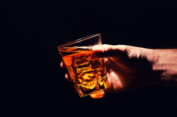 Whiskey glass in a hand of a man - Foto, afbeelding