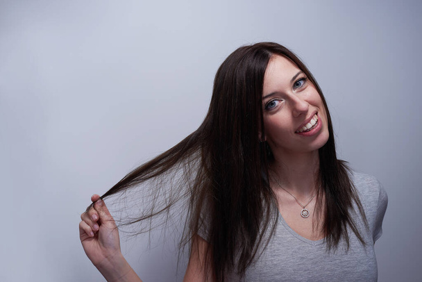 Ritratto di una donna che si tocca i capelli come se fosse danneggiata
 - Foto, immagini