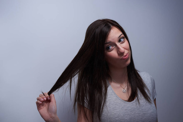 Portrait of a woman touching her hair like if it's damaged - Foto, Imagen