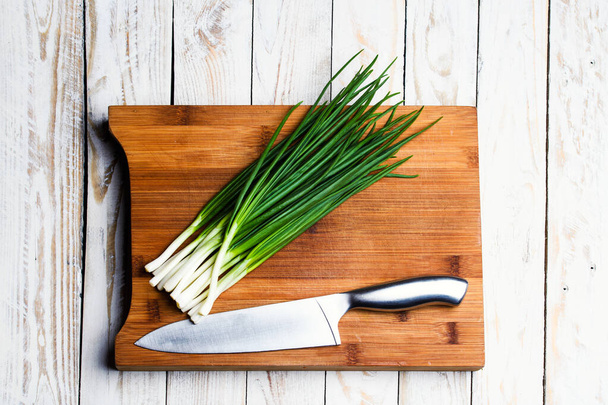 Fresh green onions on a cutting board - Foto, afbeelding